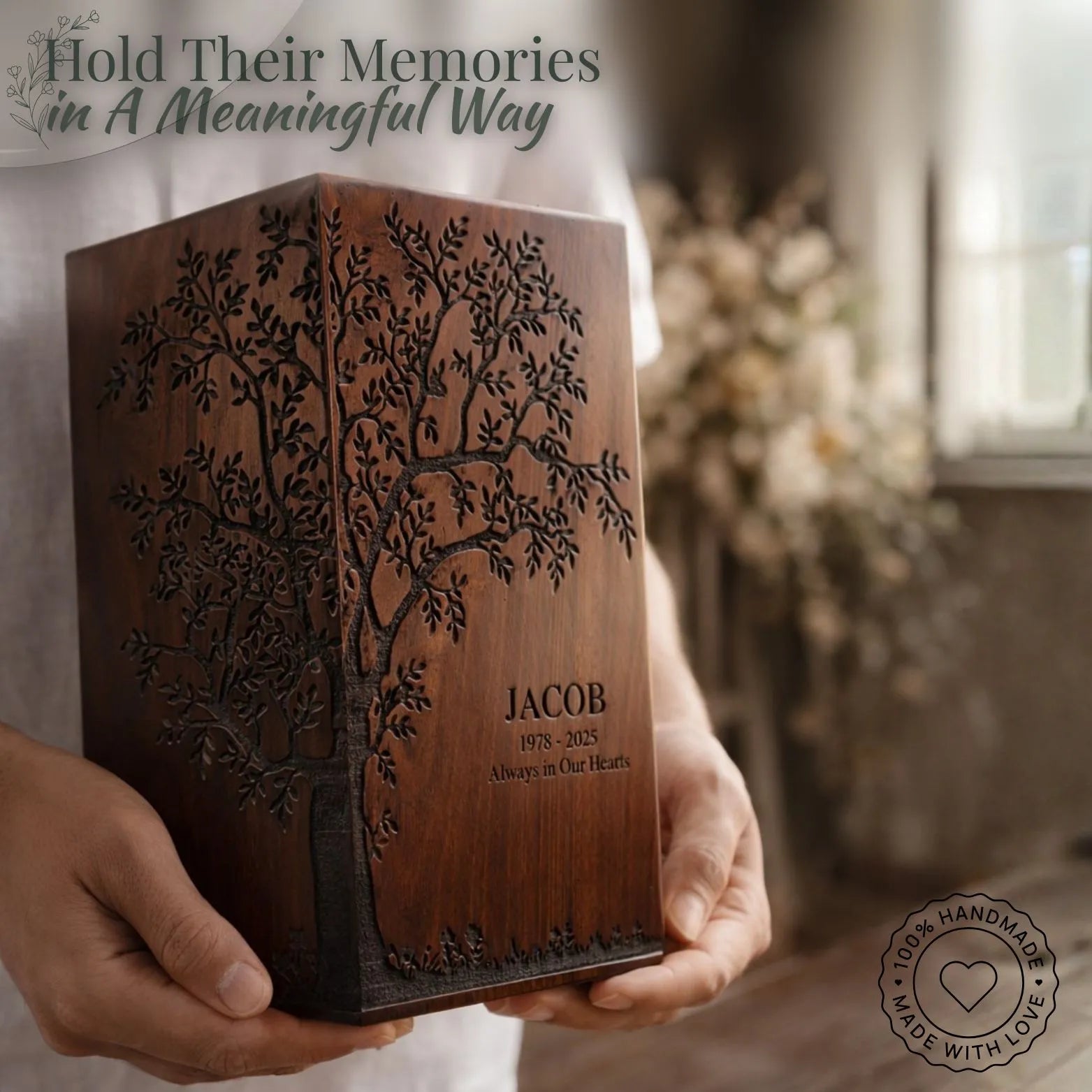 Wooden box with engraved tree design and 'JACOB' name, held by a person.
